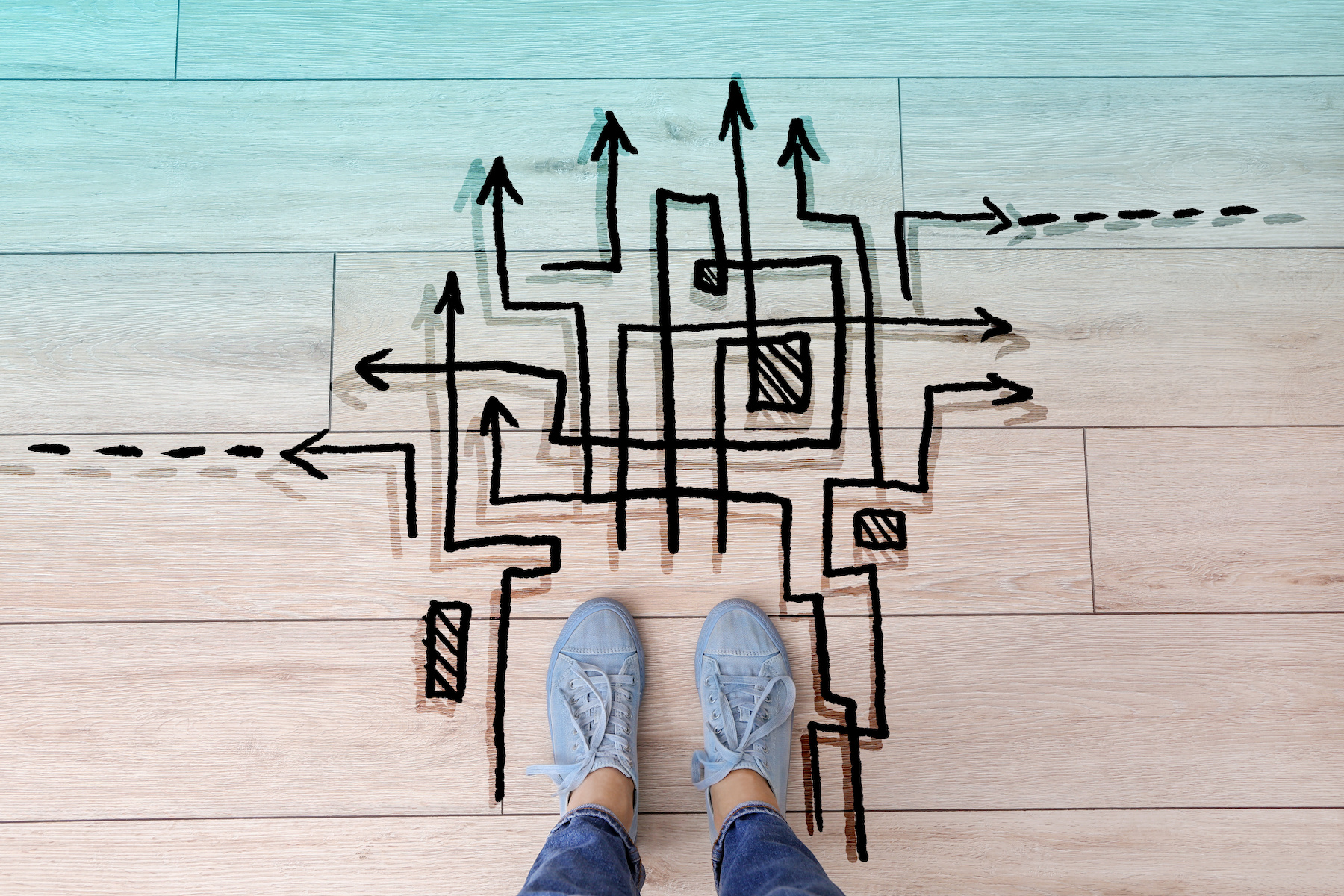 Person standing on floor near arrows pointing in different directions, top view. Concept of choice